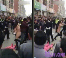 不知為何大街上女子和交警打架 見打不過就脫光衣服往懷裡撲過去 貌似地上還躺著一位
